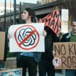 Protesters hold signs against ai and killer robots